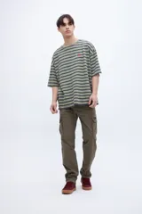 Remera verde con rayas horizontales azul marino, corte boxy y estampado con el número 1956 en el pecho.