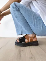 Sandalias de cuero color negro y camel, con plataforma track y hebilla ajustable.