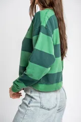 Sweater de algodón peinado con diseño de rayas horizontales en tonos verde oscuro y verde claro, de corte holgado y manga larga, con detalle de bordado en el pecho.