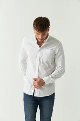 Camisa celeste de manga larga con logo bordado y bolsillo en el pecho.