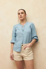 Short de jean de tiro alto color azul, con cuatro bolsillos frontales con botón.