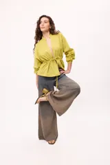 Chaqueta azul con cuello mao, mangas largas abullonadas y lazo en la cintura.