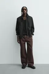 Cazadora azul marino de corte regular fit, confeccionada en tejido técnico repelente al agua. Presenta cuello subido, manga larga, bolsillos de vivo en cadera, bolsillo interior y acabados en rib en puños y bajo. Cierre frontal de cremallera oculta por solapa con botones a presión.