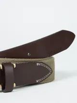 Cinturón gris oscuro con hebilla metálica plateada y detalles en cuero marrón.