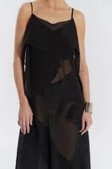 Vestido midi negro de gasa y satén, con escote recto, volados y ruedo irregular.
