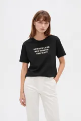 Remera negra de algodón con cuello redondo, mangas cortas y estampa frontal con la frase "Always late but worth the wait".