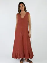 Vestido largo sin mangas de lino azul, con escote en V, bolsillos laterales y detalles de costuras marrones a la vista con terminaciones deshilachadas en el bajo.