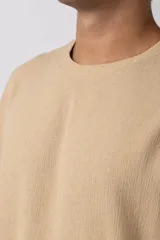 Remera de manga corta con cuello redondo, confeccionada en tejido de lino con textura entramada y corte holgado.