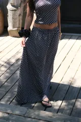 Pollera larga de viscosa, color azul marino con estampado de lunares blancos. Diseño de tiro alto y corte amplio.