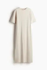 Vestido tobillero color crema, de corte recto y mangas cortas.