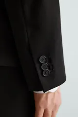 Blazer slim fit de tejido con viscosa, con cuello de solapas de muesca, manga larga con botones en puños, bolsillos de vivo en pecho y de solapa en cadera, bolsillo interior y aberturas en la espalda.