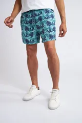 Short de baño con cintura elástica y cordón ajustable, confeccionado en tela ligera de secado rápido. Presenta un estampado botánico integral en tonos amarillos, blancos y azules, con dos bolsillos delanteros y uno posterior.