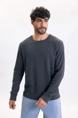 Remera de manga larga gris oscuro con textura waffle, cuello redondo y puños elásticos.