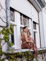 Vestido largo de estilo boho con estampado paisley en tonos tierra, naranjas y azules. Presenta un top tipo halter con espalda descubierta y elástica, y una falda larga con caída fluida y elástico en la cintura.