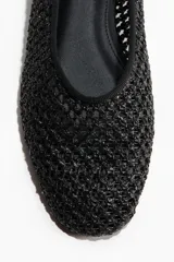 Ballerinas negras de paja de plástico trenzada con punta redondeada.