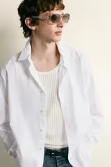 Camisa de corte regular fit confeccionada en tejido de algodón. Presenta cuello italiano, manga larga con puños abotonados y cierre frontal mediante botonadura.