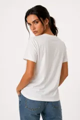 Remera de algodón color blanco off-white, de manga corta, cuello redondo a la base y corte holgado. Presenta un estampado frontal con diseño de corazón en tonos marrones y azules, con detalles de strass y texto.