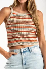 Top tejido de punto con diseño a rayas horizontales en tonos tierra, naranja y crema. Presenta un corte al cuerpo, escote halter y breteles finos.