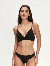 Bralette de diseño triangular confeccionado en tela suave, con breteles finos regulables y banda elástica en la base para mayor soporte.