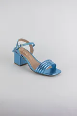 Sandalias de fiesta metalizadas color celeste, con taco cuadrado de 4 cm, tiras delanteras acolchadas y tira ajustable al tobillo con hebilla dorada.