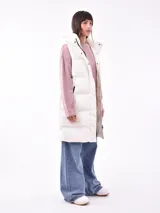 Chaleco largo acolchado color lila con capucha y bolsillos laterales.