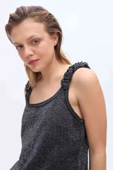 Musculosa de punto azul marino con brillo de lurex, escote redondo y breteles anchos decorados con rulos tejidos.