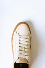 Championes urbanos de gamuza color bordó con suela de goma color caramelo y cordones blancos.