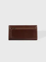 Billetera combinada de cuero en tonos marrón y camel, con solapa frontal de pelo vacuno estampado y detalle de placa con el logo de la marca.