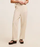 Pantalón recto de sarga color beige, de corte clásico y cintura elástica.