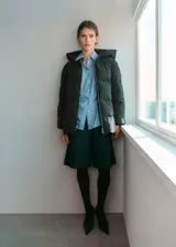 Campera puffer negra con capucha, cuello alto y cierre de cremallera doble, diseño acolchado y acabado repelente al agua.