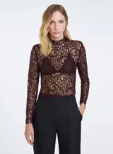 Blusa de encaje color marrón oscuro con hilos metálicos, corte entallado, cuello alto, manga larga, cierre de cremallera trasera y terminaciones efecto deshilachado.