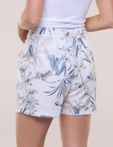Short de lino con silueta relajada, estampado en tonos azules y tierra sobre fondo blanco. Posee cintura elastizada con cordón ajustable, bolsillos laterales y dobladillo en las piernas.