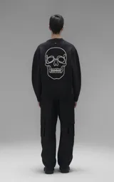 Sweater de cuello redondo color negro, con diseño de calavera bordado en relieve en color blanco en la espalda. Presenta terminaciones en punto rib en cuello, puños y ruedo, con un calce relajado y oversize.
