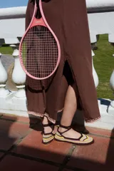 Zapato plano tipo ballerina, tejido a mano en crochet con rayas horizontales en tonos marrón, amarillo y blanco. Tiene tiras para atar al tobillo y suela de cuero intervenida con crochet.