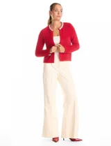 Chaqueta de tejido mohair color rojo, con cuello a la base decorado con bordado de perlas y canutillos. Presenta cierre frontal con broche interno, bolsillos simulados y detalles de apliques brillantes en los bordes.