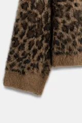 Jersey de punto con textura suave, cuello redondo y manga larga. Presenta un estampado animal print en tonos marrones y cierre frontal con botones.