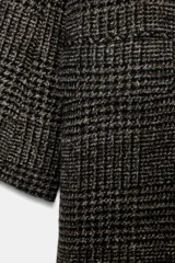 Abrigo largo de Zara Woman Collection, confeccionado en tejido con mezcla de lana. Presenta un diseño de cuadros, cuello con solapas de muesca, cierre frontal cruzado con botones y bolsillos delanteros. Incluye forro interior.