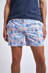 Short de baño con estampado tropical de piñas y hojas en tonos azules sobre fondo rosado. Cuenta con cintura elástica con cordón ajustable, bolsillos laterales, un bolsillo trasero y suspensor interno.