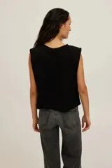Musculosa de punto de algodón ligero y suave, color negro, con escote redondo, hombros estructurados y corte recto con largo ligeramente corto.