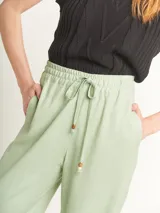 Pantalón de lino color lila, tiro alto, corte palazzo con elástico en la pretina, bolsillos laterales y dobladillo invisible.