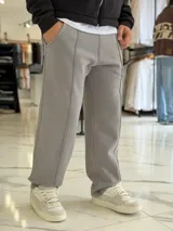 Pantalón jogging oversize de felpa, color gris, de corte recto y diseño cómodo con costuras frontales en relieve.