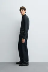 Camisa negra de corte slim fit, con cuello italiano y manga larga con puño abotonado. Cierre frontal de botonadura.