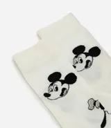 Par de medias de caña larga color blanco, con estampado de personajes de Disney en negro y detalles en puntera y talón en color negro.