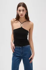 Top negro de corte ajustado al cuerpo, con diseño de cuello halter y detalle de aro metálico en el centro del escote.