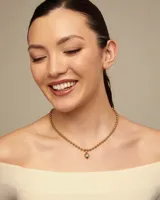 Collar de cadena formado por esferas continuas, con cierre de mosquetón y cadena de extensión. Está fabricado en una aleación de metales con baño de oro de 18k.
