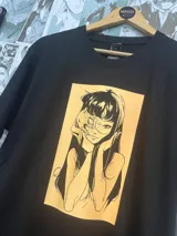 Remera negra de manga corta con estampado de Tomie de Junji Ito en color amarillo fotoluminiscente.