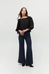 Blusa color rosa pálido de algodón con mangas cortas abullonadas y volados en el escote.