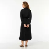 Vestido camisero largo negro con botones dorados, cinturón de lazo y abertura frontal.