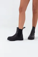 Bota Chelsea de cuero color negro, con elásticos laterales y suela track.