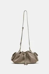 Mini bolso bandolera de piel color gris topo, con diseño fruncido, cierre mediante cordón ajustable y stopper, bolsillos exteriores laterales con solapa y botón imantado, y correa ajustable.